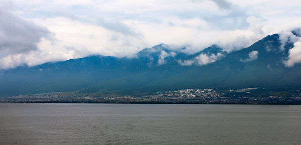 Scenic view of sea by city against sky