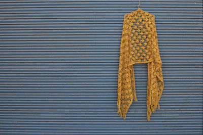 Orange scarf hanging on closed shutter