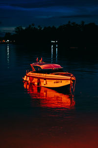 Boat moored in lake against sky at night