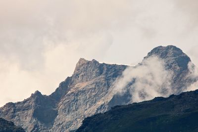 Low angle view of rocky mountains against sky