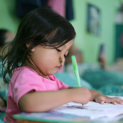 Close-up of girl making face on table