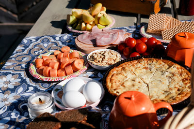 Picnic table set -nuts, pie, eggs, tomatoes, carrots. harvest table outside