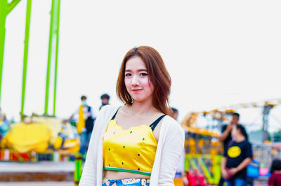 Portrait of young woman standing in amusement park