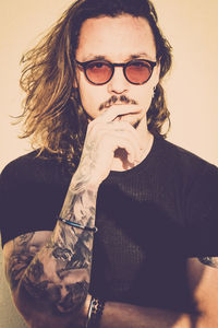 Portrait of confident tattooed man wearing sunglasses