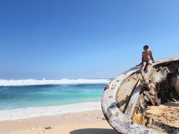 Man on beach against blue sky