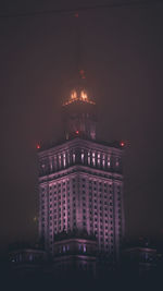 Low angle view of illuminated buildings against sky at night
