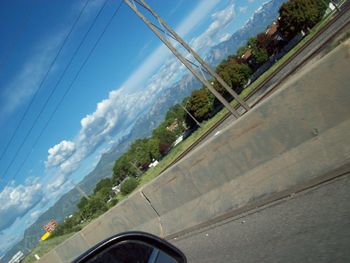 Car on road by bridge against sky