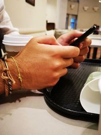 Close-up of man using laptop on table