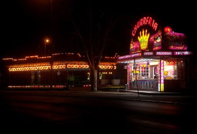 Illuminated building by street at night