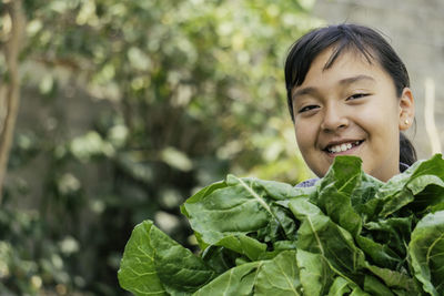 Close-up of young woman holding plant