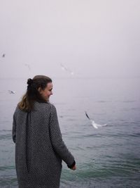 Woman standing against sea