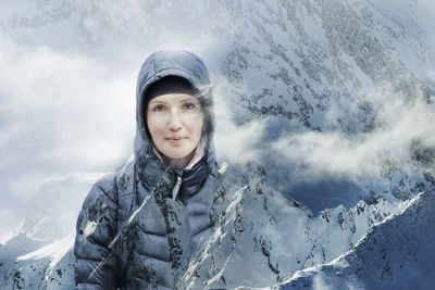 Portrait of woman standing on snowcapped mountain during winter