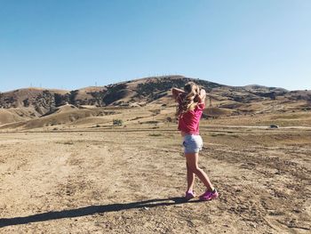 Full length of woman walking on land against clear sky