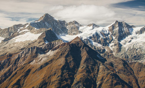 Low angle view of snowcapped mountains against sky