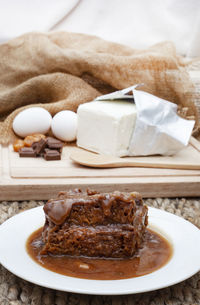 Sticky toffee pudding serving with selective focus and ingredients in background