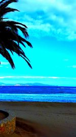 Palm tree on beach against blue sky