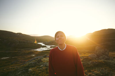 Portrait of young man standing against mountain