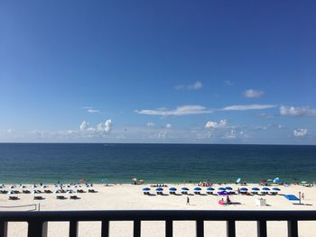 People on beach against blue sky