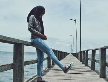 Woman standing on wooden pier