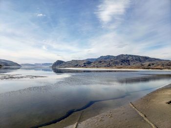 Scenic view of lake by mountain against sky
