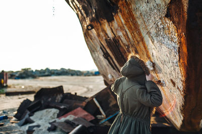 Rear view of a woman against rough wood