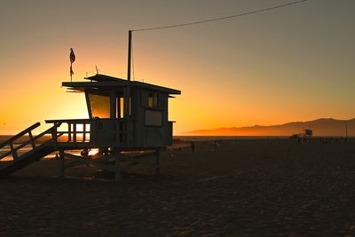 Lifeguard hut at beach during sunset