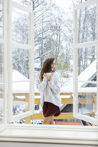 Portrait of young woman standing in balcony