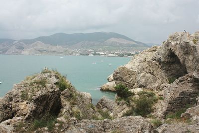 Scenic view of sea and mountains against sky