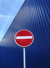 Low angle view of road sign against blue sky