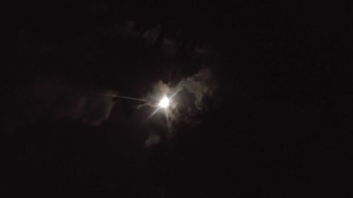 Low angle view of illuminated moon against sky at night