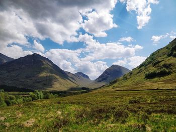 Scenic view of field and mountains against sky