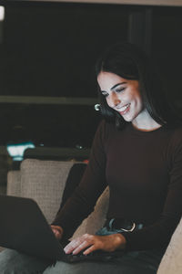 Young woman using laptop while sitting at home