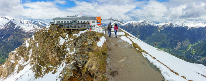 Rear view of man on snowcapped mountains against sky