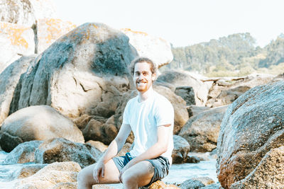 Portrait of woman sitting on rock