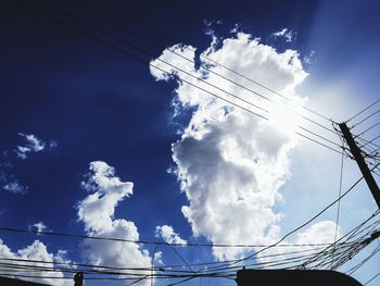 Low angle view of electricity pylon against blue sky