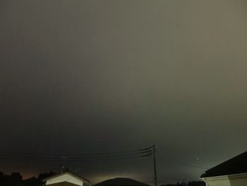 Low angle view of silhouette cables against sky