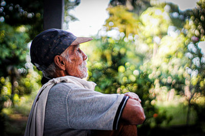 Portrait of man wearing hat against trees