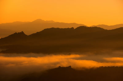 Fog and golden light in the morning forest with green mountains. baan jabo, mae hong son, thailand.