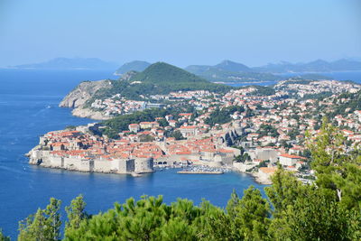 High angle view of townscape by sea against sky