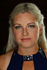 A pretty young woman with long blonde hair and a sleeveless blue dress.