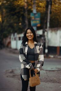 Portrait of young woman standing outdoors