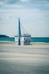 Lifeguard hut on sea shore against sky