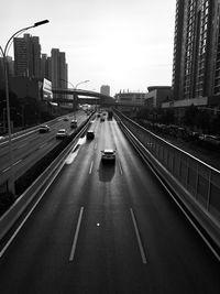 Vehicles on road in city against sky