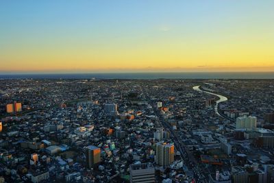 High angle view of city buildings against sky during sunset