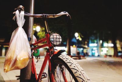 Close-up of plastic bag hanging on bicycle at night