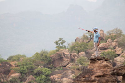 Man standing on rock against mountain