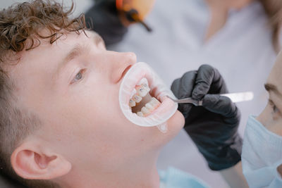 Close-up of woman applying dentures