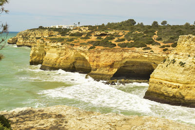 Rock formations by sea against sky