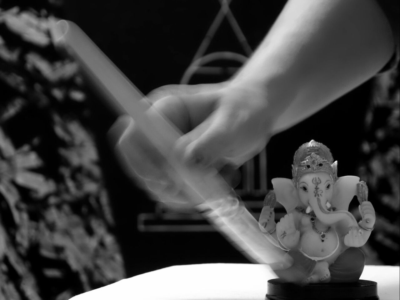 CLOSE-UP OF WOMAN HAND WITH STATUE