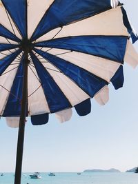 Low angle view of flags against clear blue sky